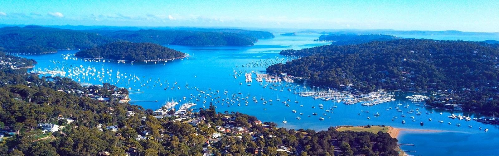Aerial panorama of Pittwater with moored boats, marinas and bushland